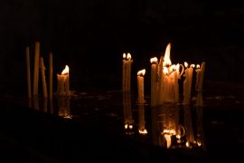 Candles flame reflection in water in dark